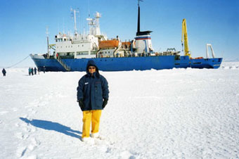 Homem na neve, com roupas de freio e um navio atrás em um dos Lugares Do Planeta Que Se Deve Conhecer.